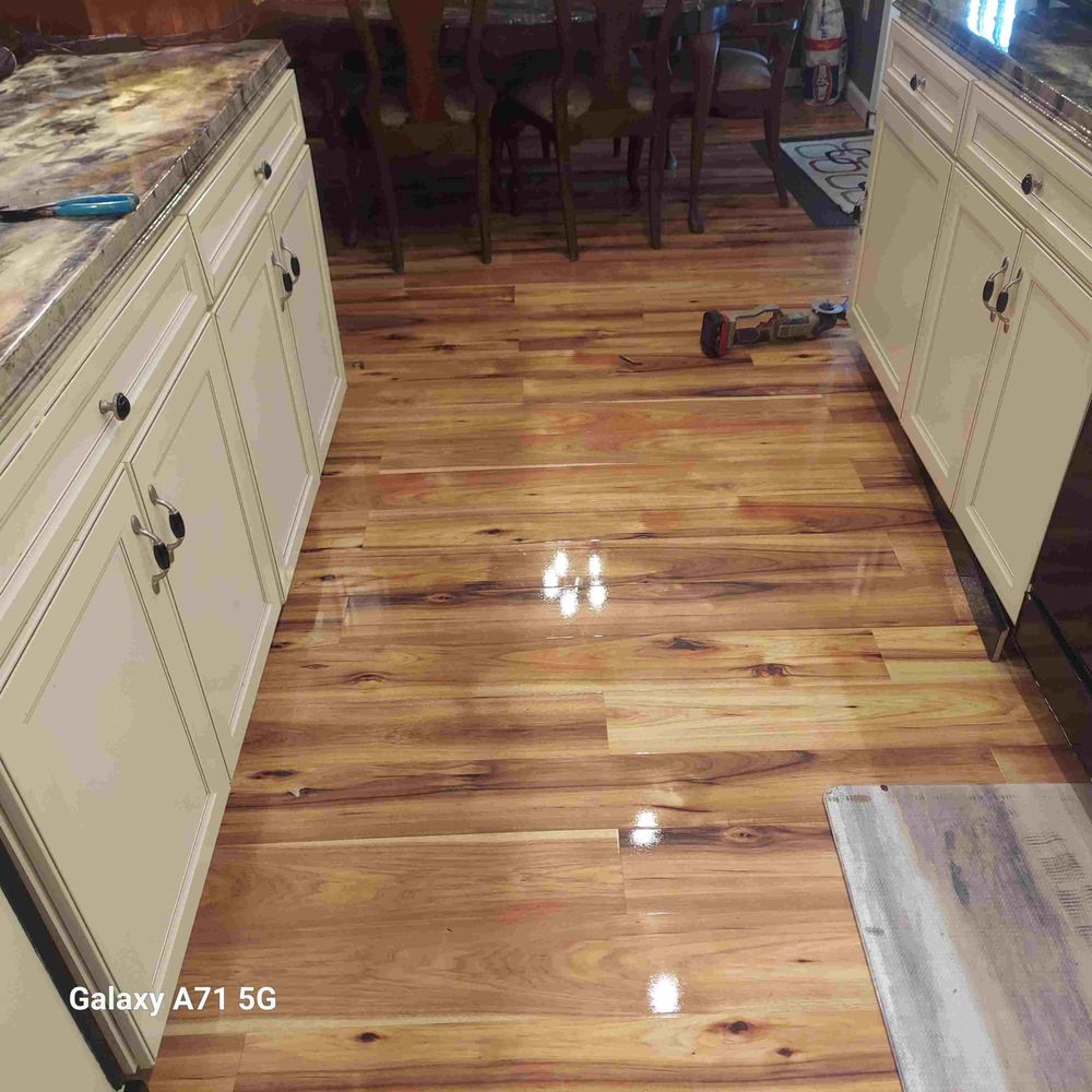 Newly installed hardwood flooring running through a kitchen and dining area
